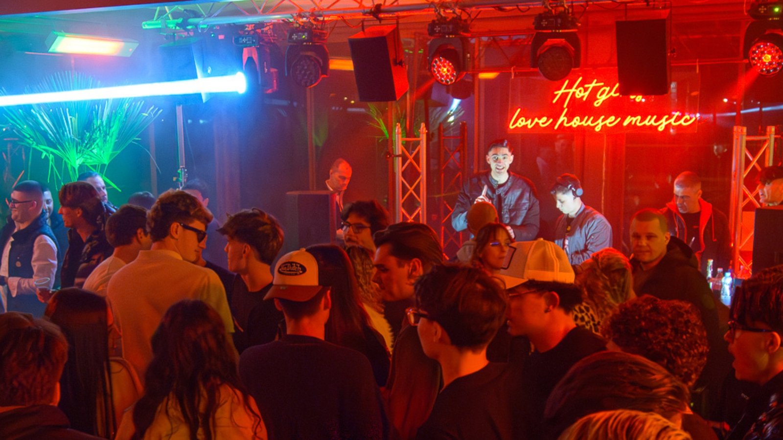 Dark ceiling trusses and a single warm spot above a club floor.